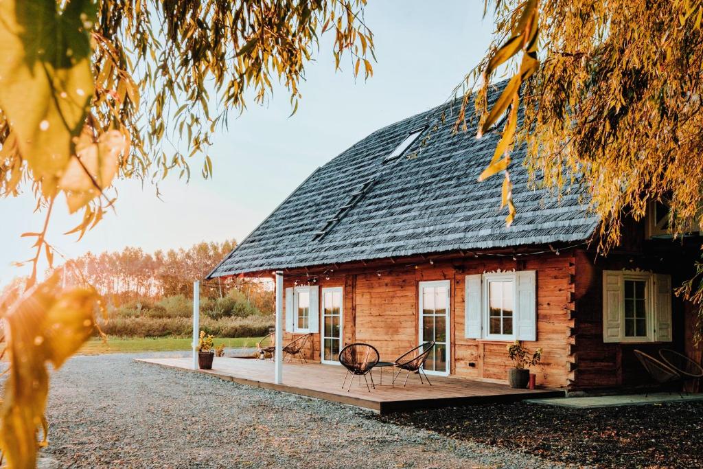 a log cabin with a metal roof on a porch at Chatka Pradziadka i Jurty na Wodzie in Pokrówka