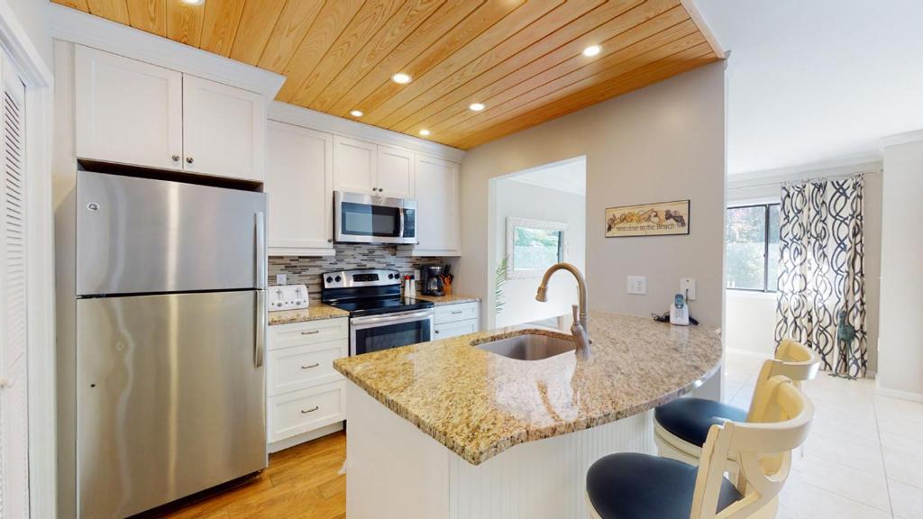 a kitchen with white cabinets and a stainless steel refrigerator at 213 Turnberry Village in Hilton Head Island