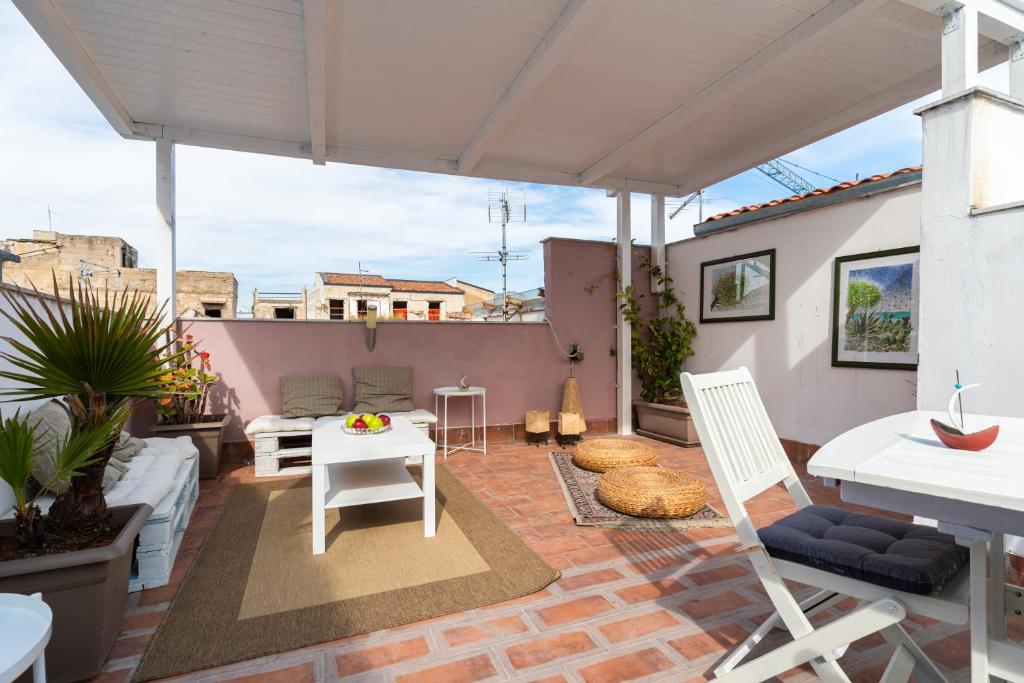 eine Terrasse mit einem Tisch und Stühlen auf dem Dach in der Unterkunft Attico Sesto Canto in Palermo