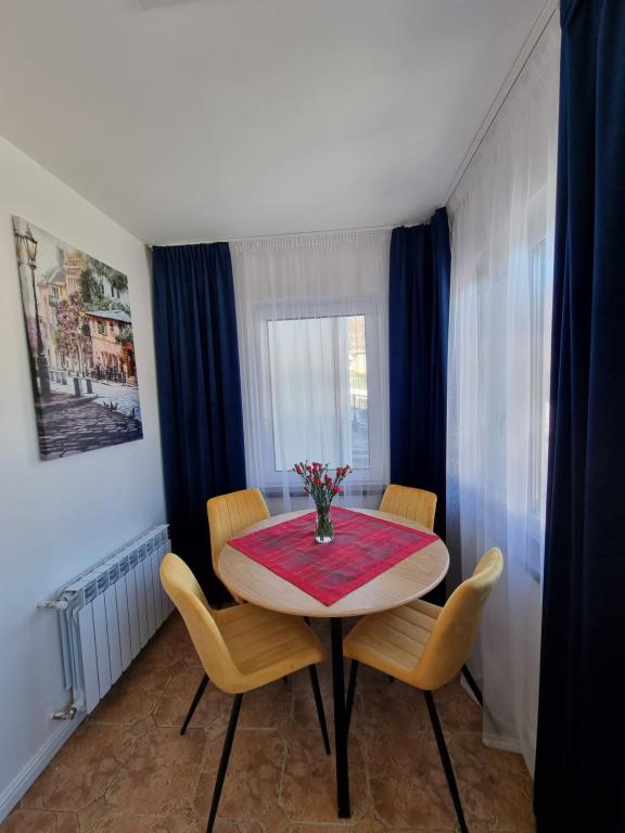 a dining room with a table and chairs and a window at Apartamenty Kolorowa in Szczyrk