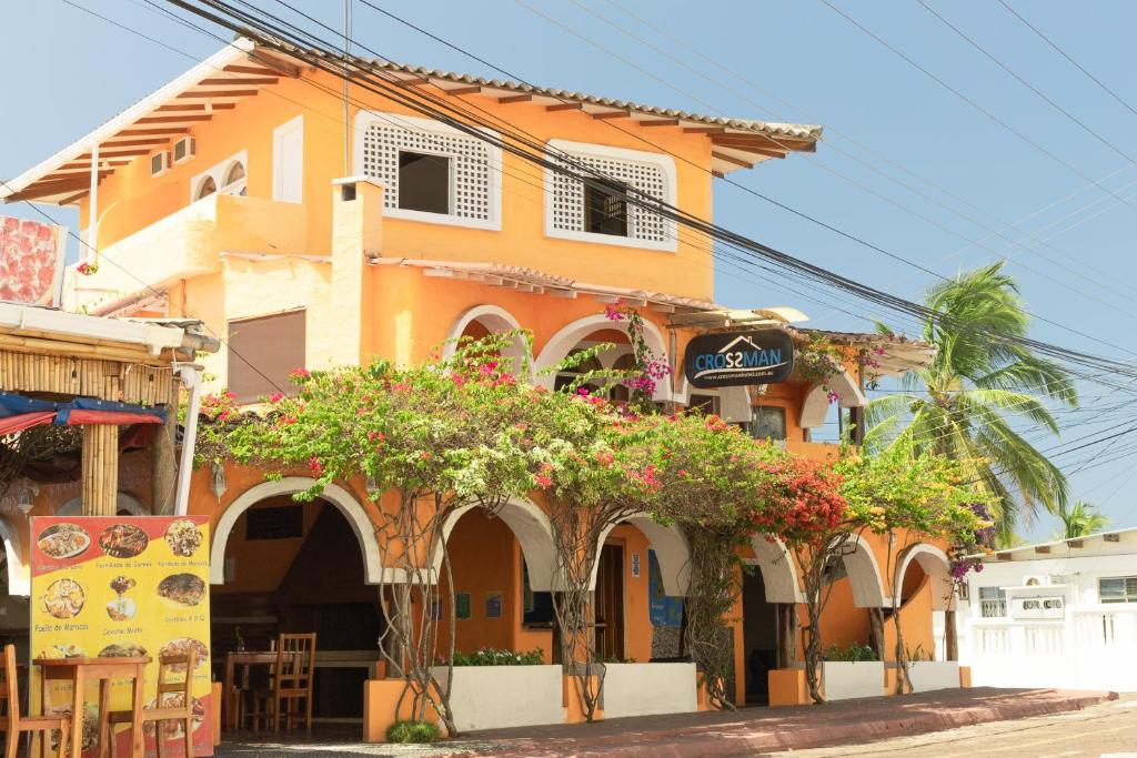 ein orangefarbenes Gebäude mit Pflanzen davor in der Unterkunft Hotel Crossman in Puerto Ayora