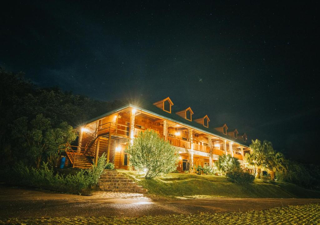 un grand bâtiment en bois avec des lumières allumées la nuit dans l'établissement Hotel Heliconia - Monteverde, à Monteverde Costa Rica