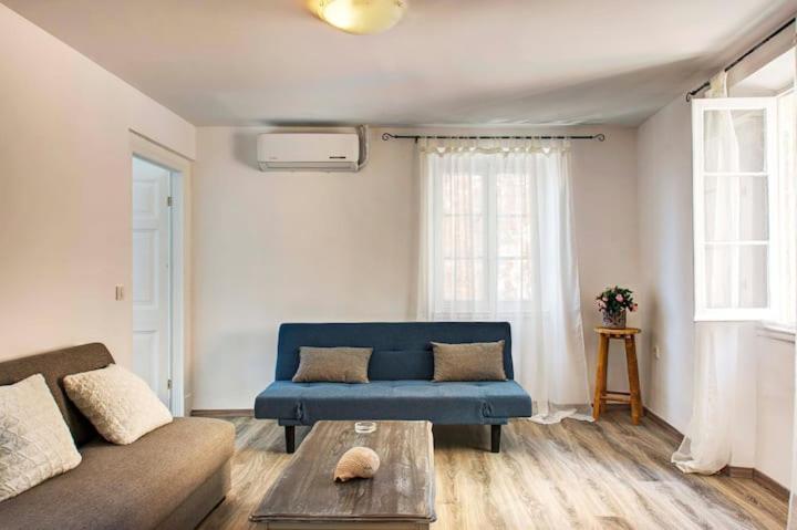 a living room with a blue couch and a table at Casa di Roza in Corfu