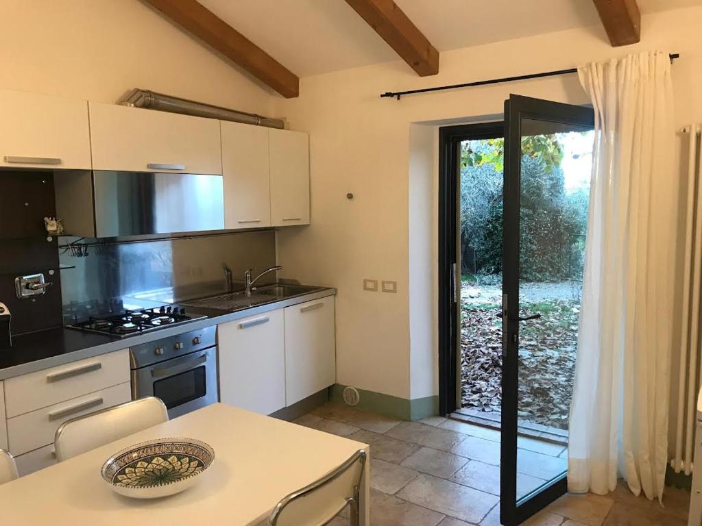 a kitchen with white cabinets and a table and a window at La casina in Acquaviva