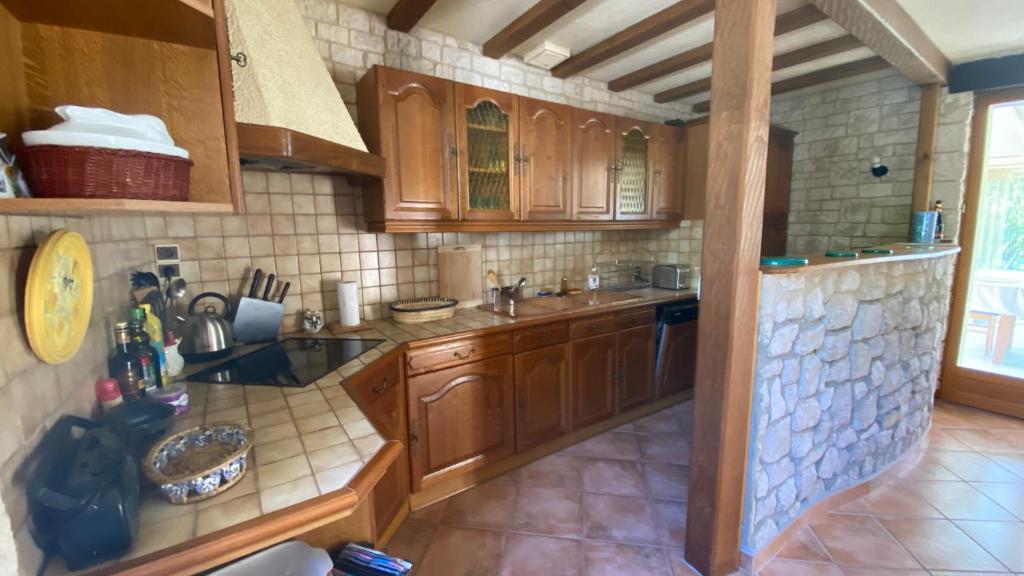 une cuisine avec des armoires en bois et un comptoir dans l'établissement La nébuleuse, à Notre-Dame-de-lʼIsle