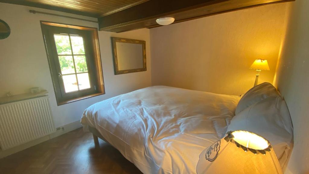 niewielka sypialnia z łóżkiem i oknem w obiekcie La nébuleuse w mieście Notre-Dame-de-lʼIsle