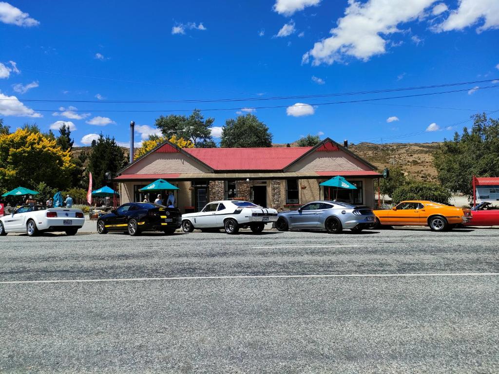 a group of cars parked in front of a building at Oturehua Railway Hotel Cottage in Oturehua