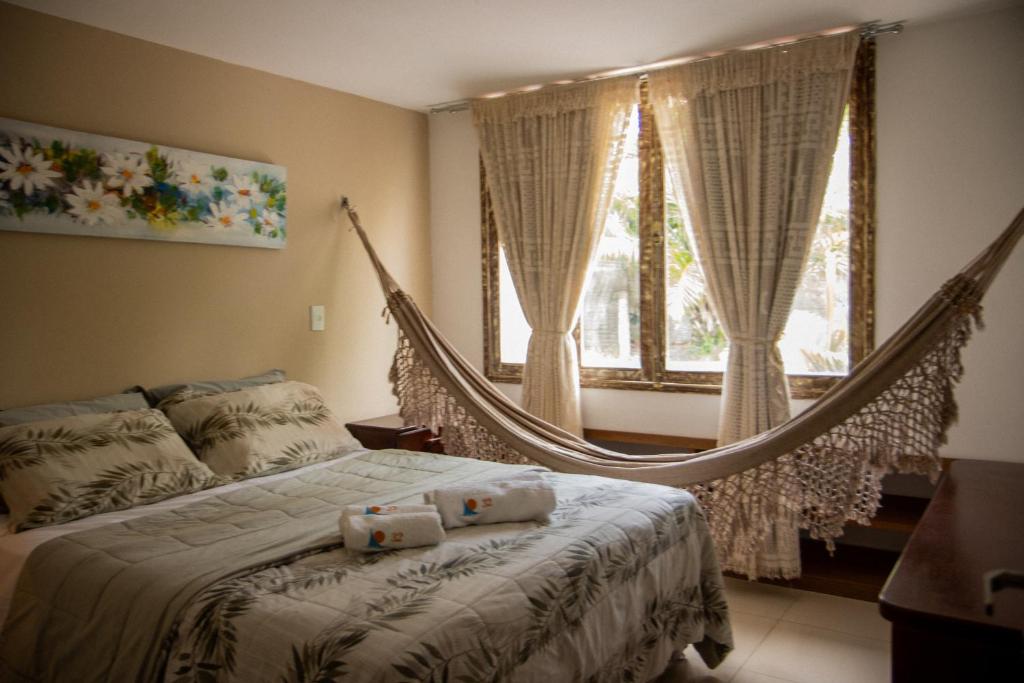 皮帕Bangalô Pipa Resort的卧室配有吊床,位于窗户前