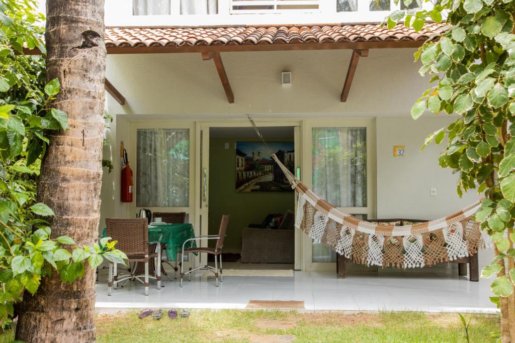 a porch with a hammock in front of a house at Bangalô Pipa Resort in Pipa