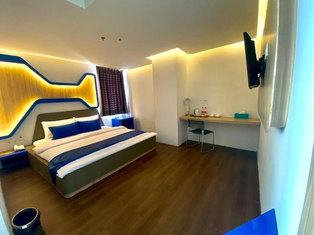 een slaapkamer met een groot bed en een bureau bij Golden Palace Hotel in Batu Merah