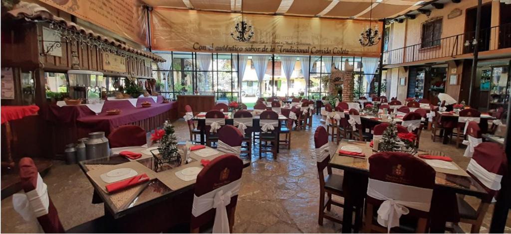 a dining room with tables and chairs in a building at Nuestras Raíces Hotel - Museo - Restaurante in San Cristóbal de Las Casas
