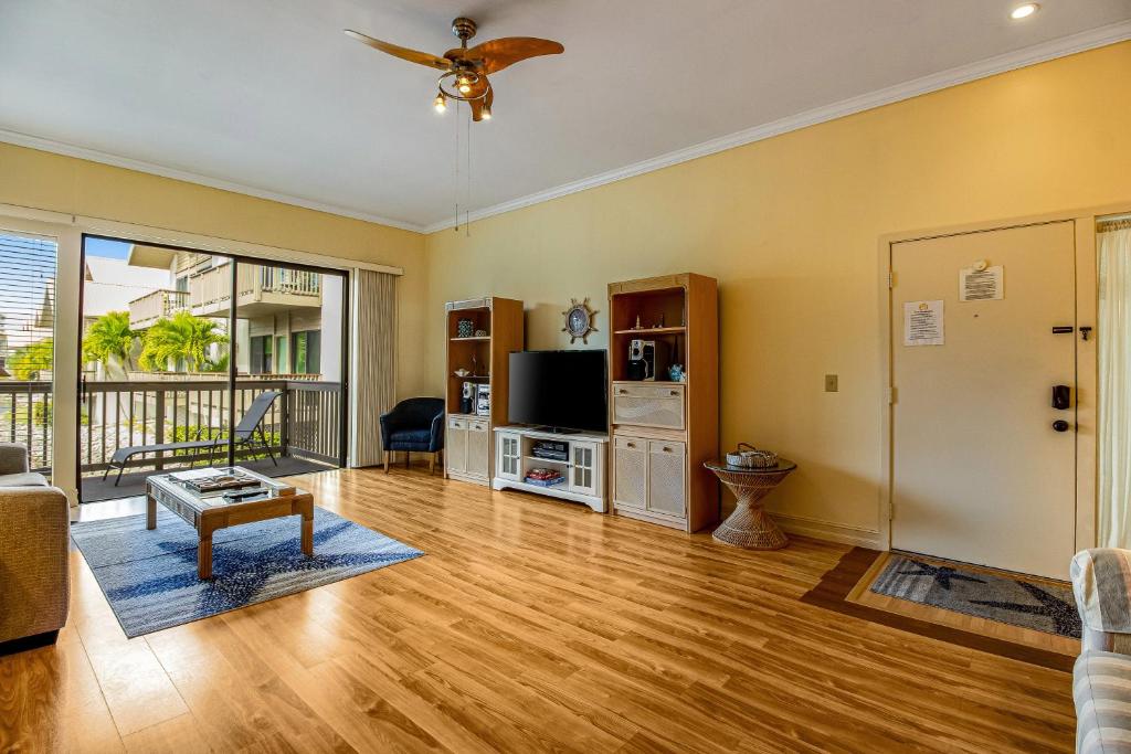 a living room with wooden floors and a ceiling fan at Salt & Serenity in Siesta Key