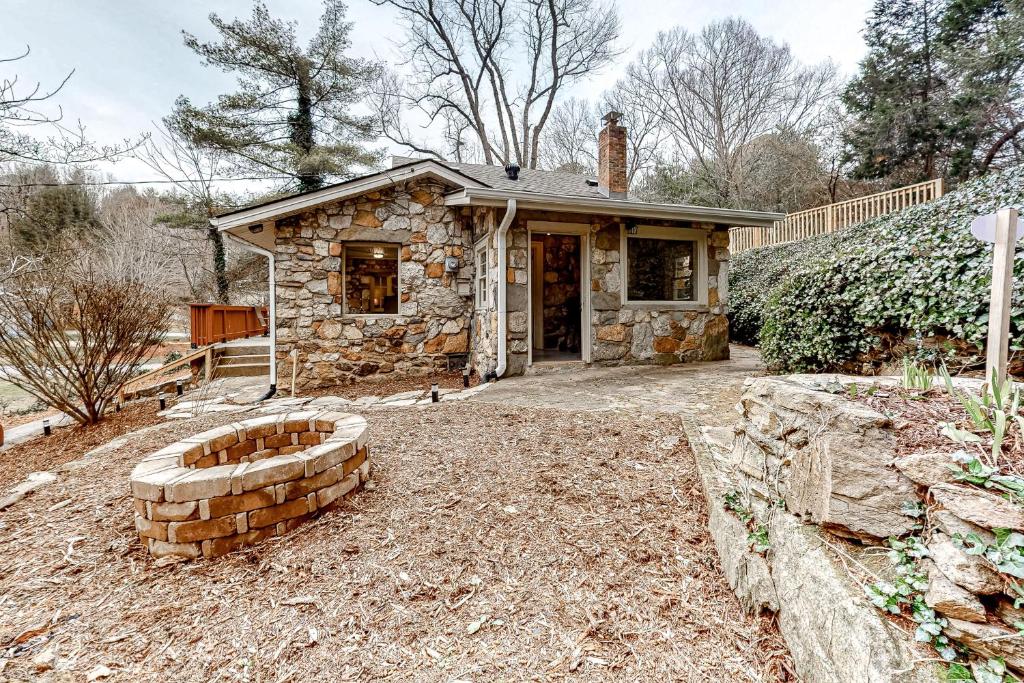 una pequeña casa de piedra con un patio de ladrillo en Squirrels Nest en Asheville