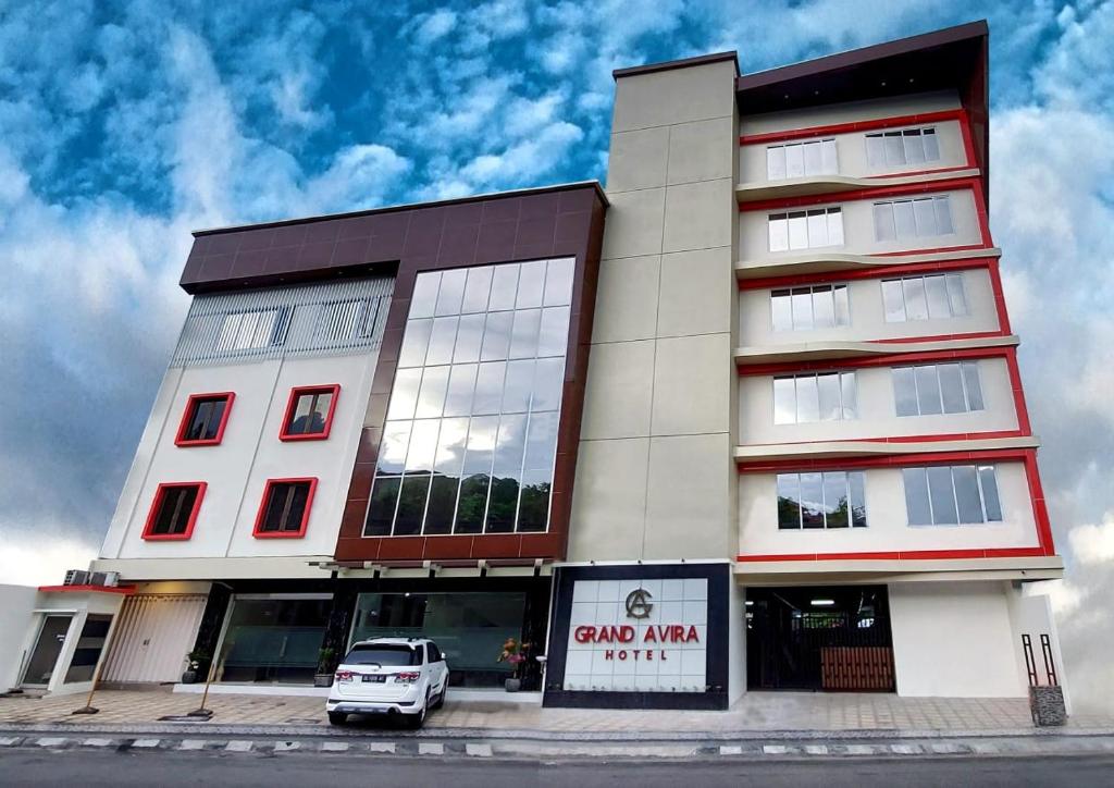 ein Gebäude mit einem davor geparkt in der Unterkunft Grand Avira Hotel in Batu Merah