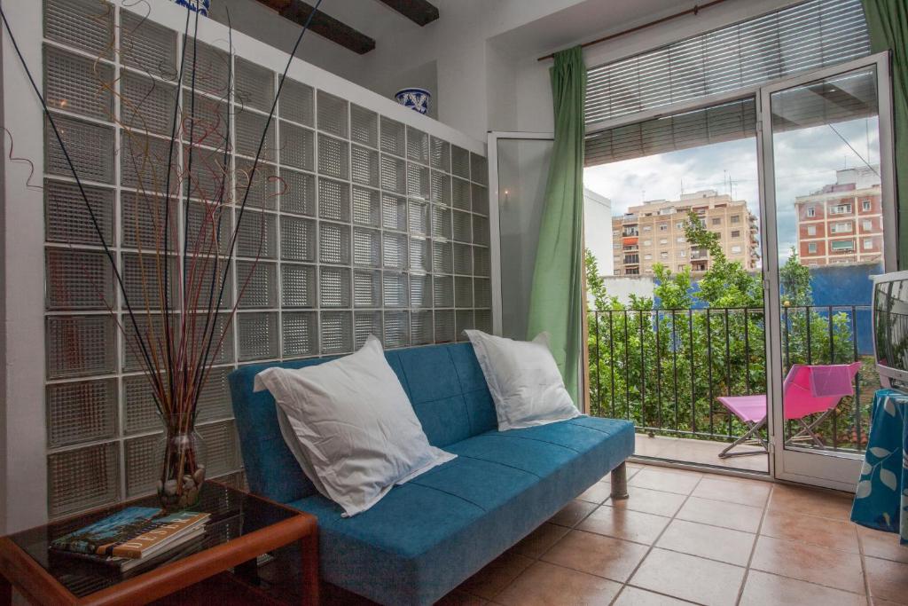 a blue couch in a living room with a window at Maritim Apartments in Valencia