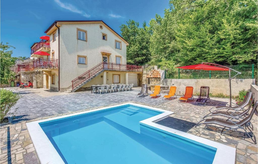 a house with a swimming pool in front of a house at 2 Bedroom Cozy Apartment In Grizane in Kostelj