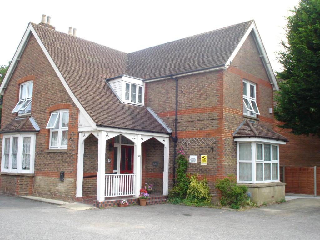 a red brick house with a gambrel roof at Masslink Guest House in Horley