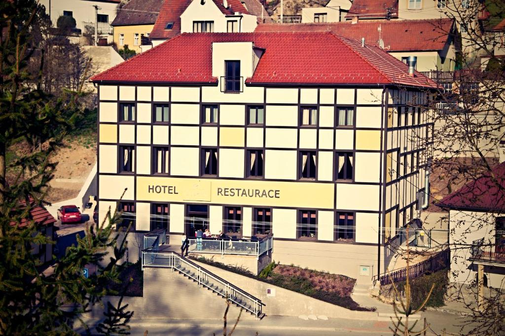 un bâtiment d'hôtel avec un toit rouge dans une ville dans l'établissement Hotel Olberg, à Olomučany