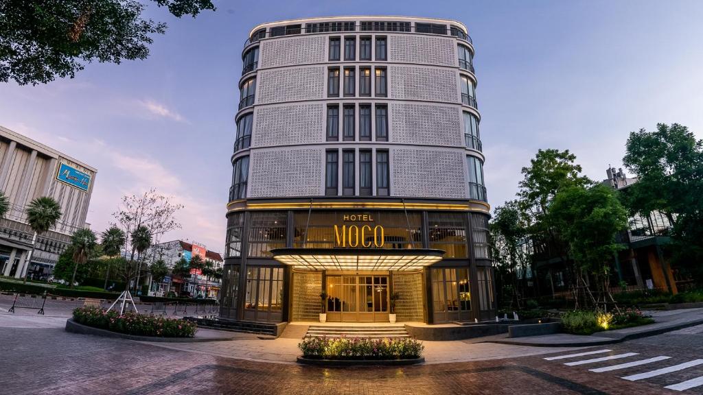 a hotel building with a sign in front of it at Hotel MOCO in Udon Thani