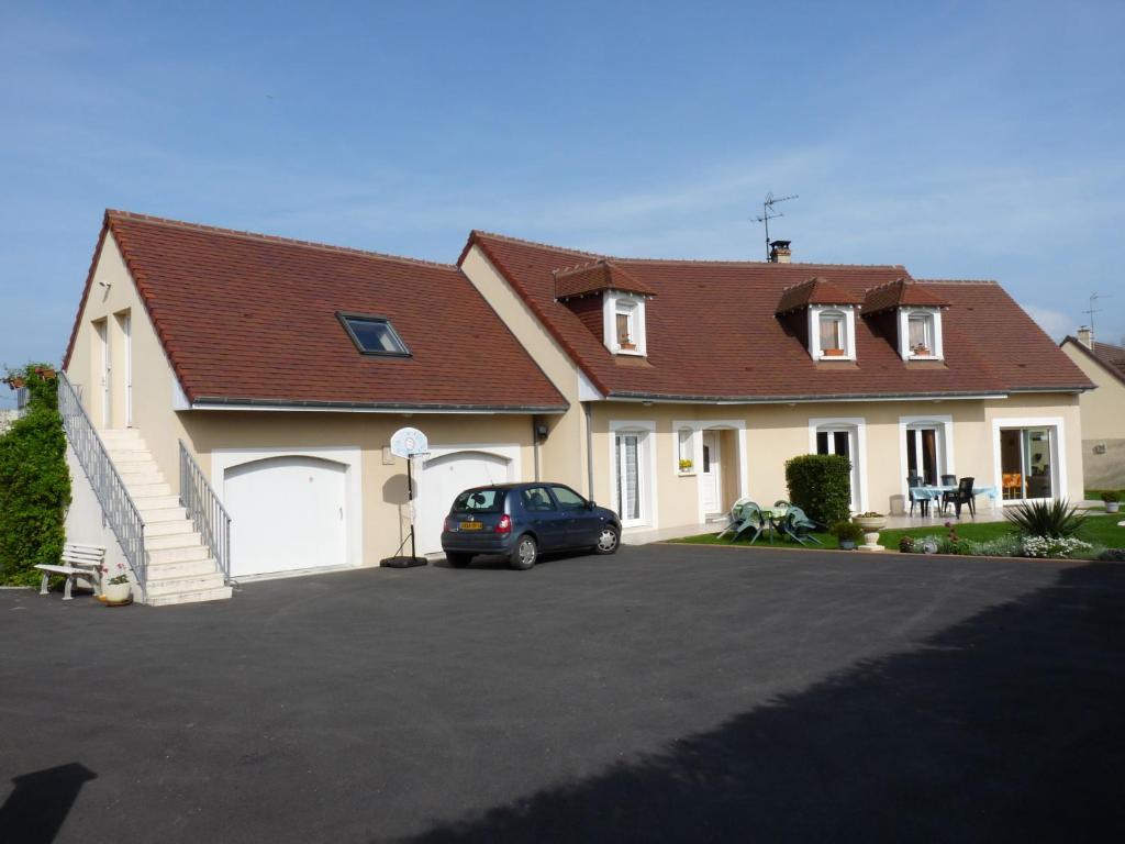 una casa con un coche aparcado en una entrada en CHAMBRE STUDIO avec KICHENETTE SOLEIL DE NACRE, en Hermanville-sur-Mer