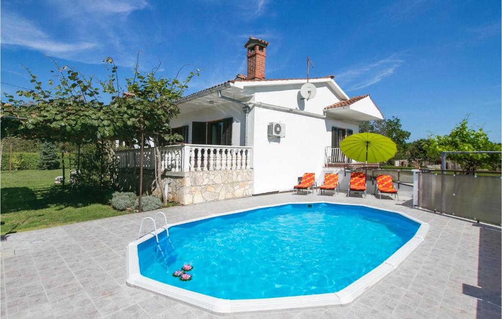 a swimming pool in front of a house at Beautiful Home In Nedescina With Outdoor Swimming Pool in Ružići
