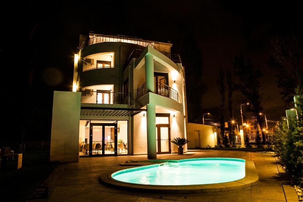 un edificio con una piscina frente a él por la noche en El Locanda Boutique Hotel, en Constanţa