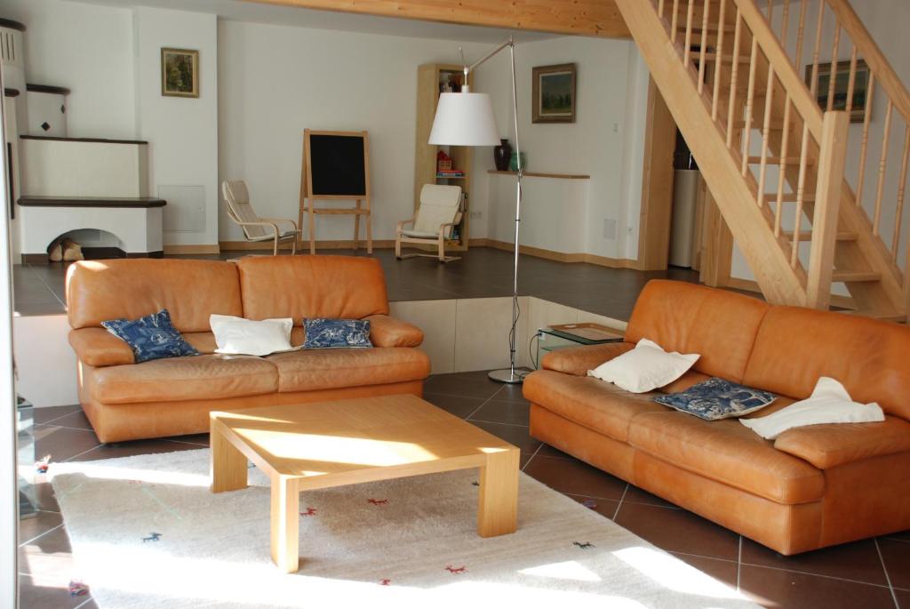a living room with two leather couches and a table at Les Bleuets in Scharrachbergheim Irmstett