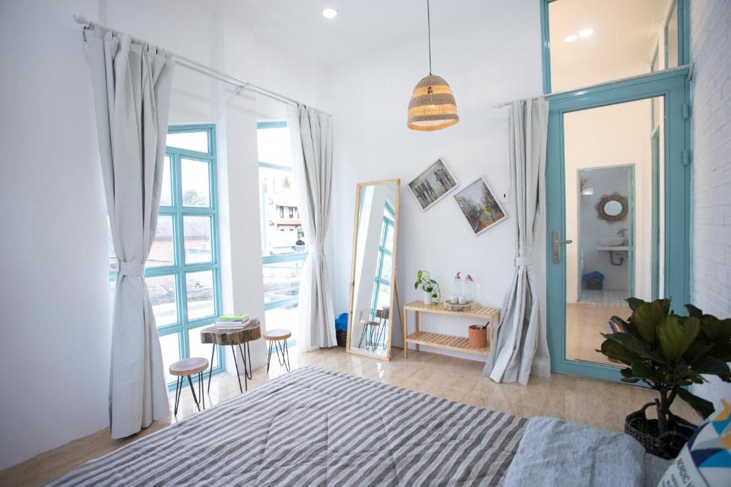 Ấp Thiện Phước的住宿－Ẩn Homestay Mũi Né，一间卧室设有一张床和一个大窗户