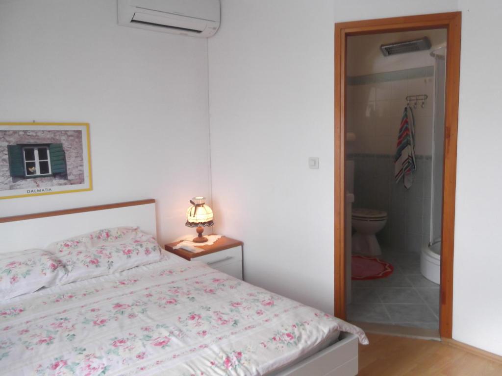 a bedroom with a bed and a bathroom at Apartments Vanda in Vrboska