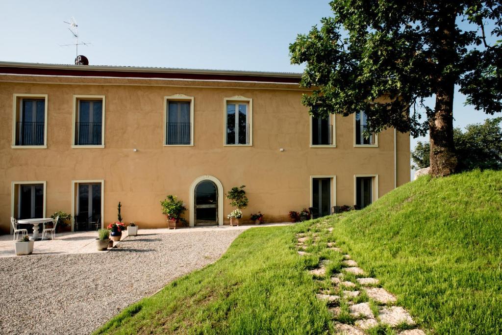 um edifício com uma colina relvada em frente em Agriturismo Panorama em Castelnuovo del Garda