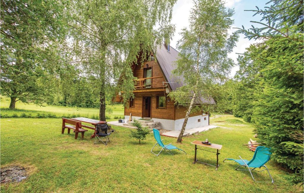 une cabane en rondins avec des chaises et des tables dans la cour dans l'établissement Cozy Home In Delnice With Kitchen, à Delnice