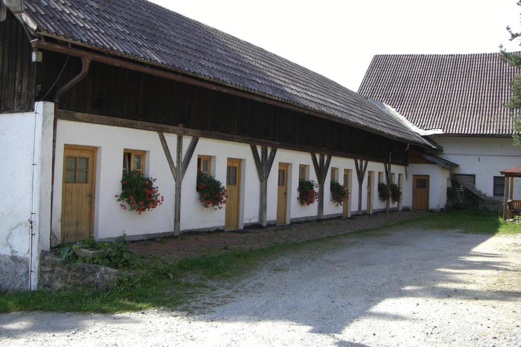 a white building with a black roof and flowers on the windows at Landgasthof Düllhof in Schaufling