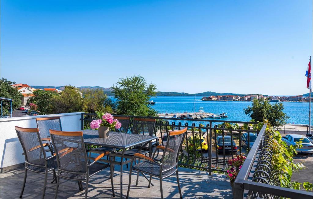a table and chairs on a balcony with a view of the water at Nice Apartment In Sibenik With 3 Bedrooms And Wifi in Šibenik