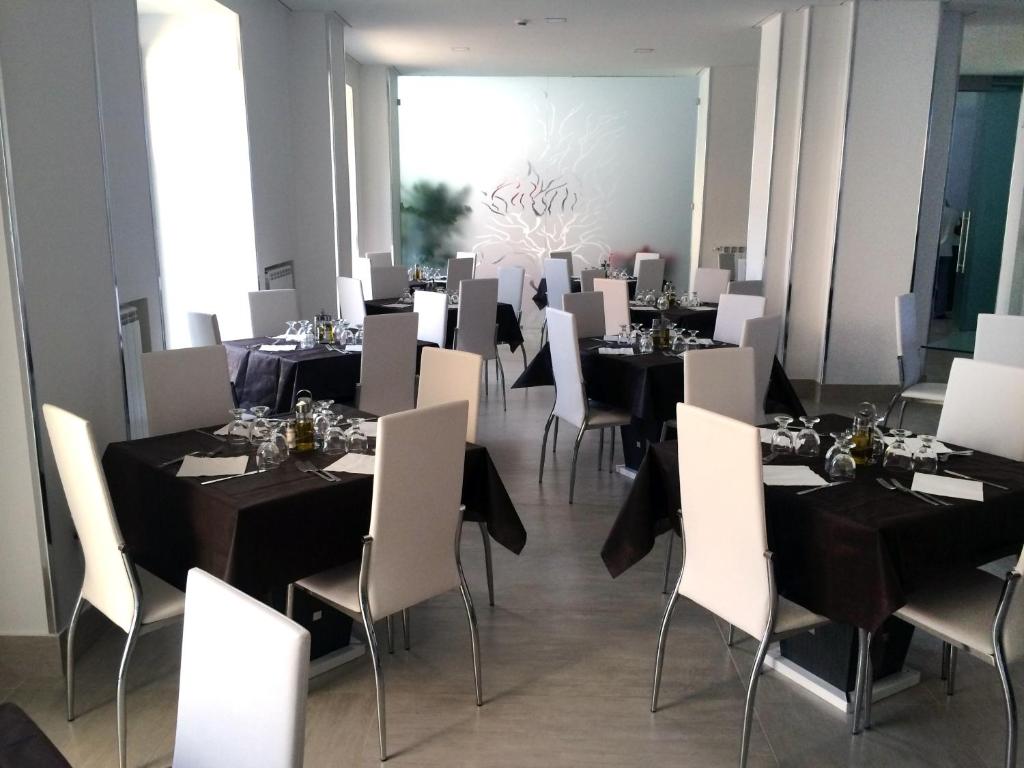 jadalnia z czarnymi stołami i białymi krzesłami w obiekcie Hotel Regina w mieście Caserta