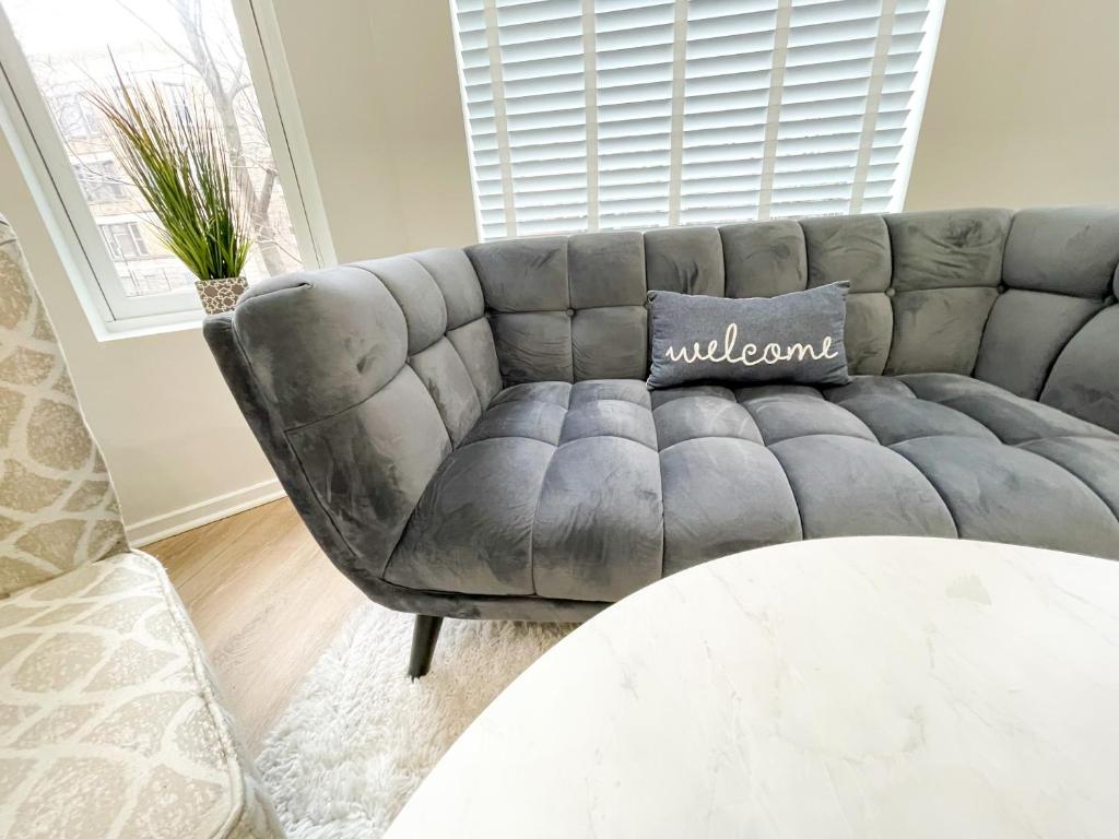 un sofá gris en una sala de estar con mesa en Wrigleyville Friends Unit - 5bdrm, en Chicago