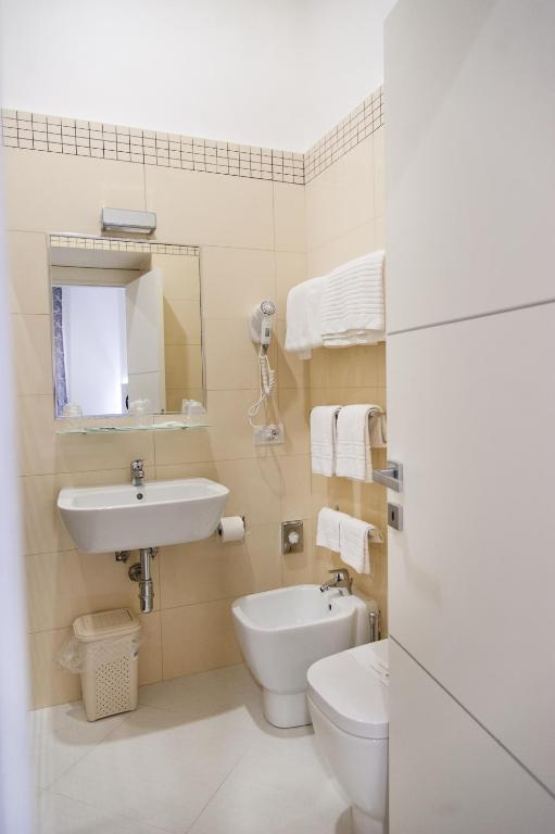 biała łazienka z umywalką i toaletą w obiekcie Hotel Regina w mieście Caserta