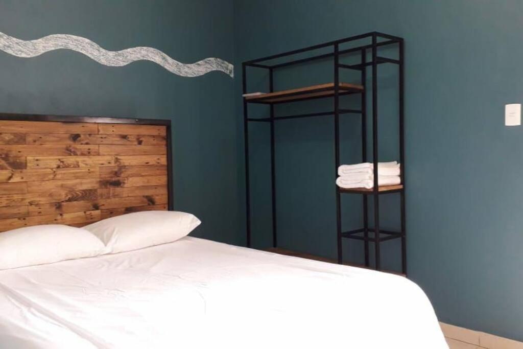 a bedroom with a white bed and a blue wall at Nice house Casa de Descanso en San Andrés Tuxtla. in San Andrés Tuxtla