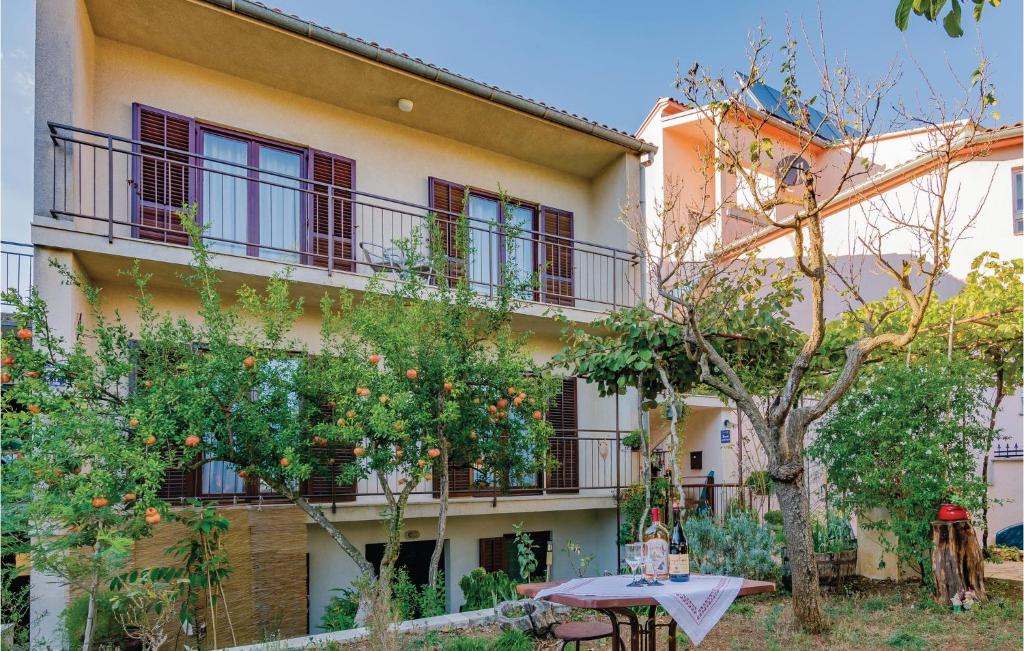 een gebouw met een tafel en bomen ervoor bij Stunning Apartment In Fazana With Wifi in Fažana