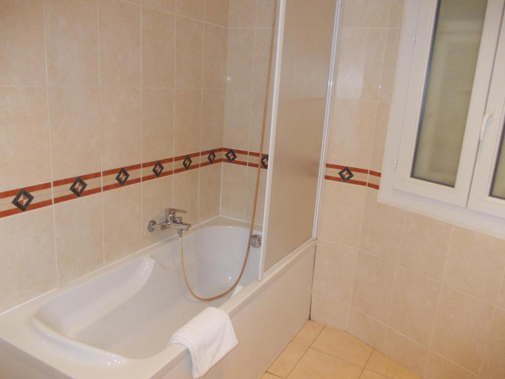 a bathroom with a shower and a tub and a sink at Hotel Marcellin in Beaulieu-sur-Mer