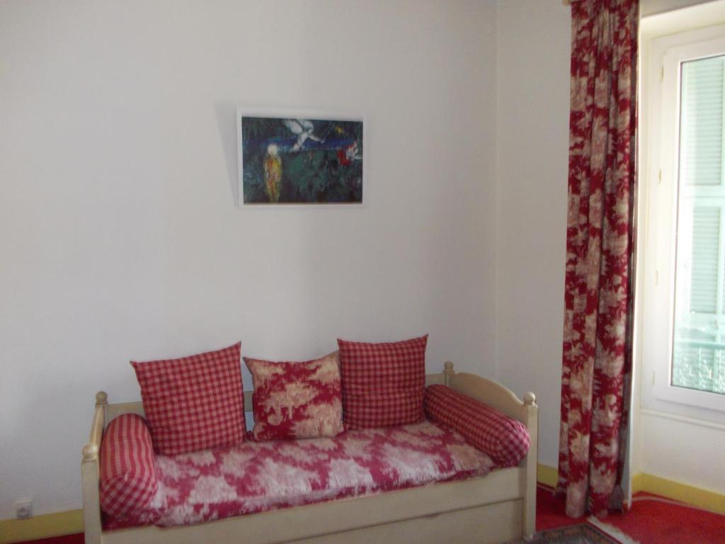 a couch sitting in a room with a window at Hotel Marcellin in Beaulieu-sur-Mer