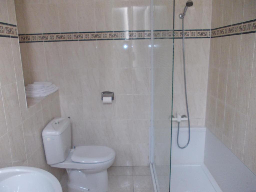 a bathroom with a shower and a toilet and a sink at Hotel Marcellin in Beaulieu-sur-Mer