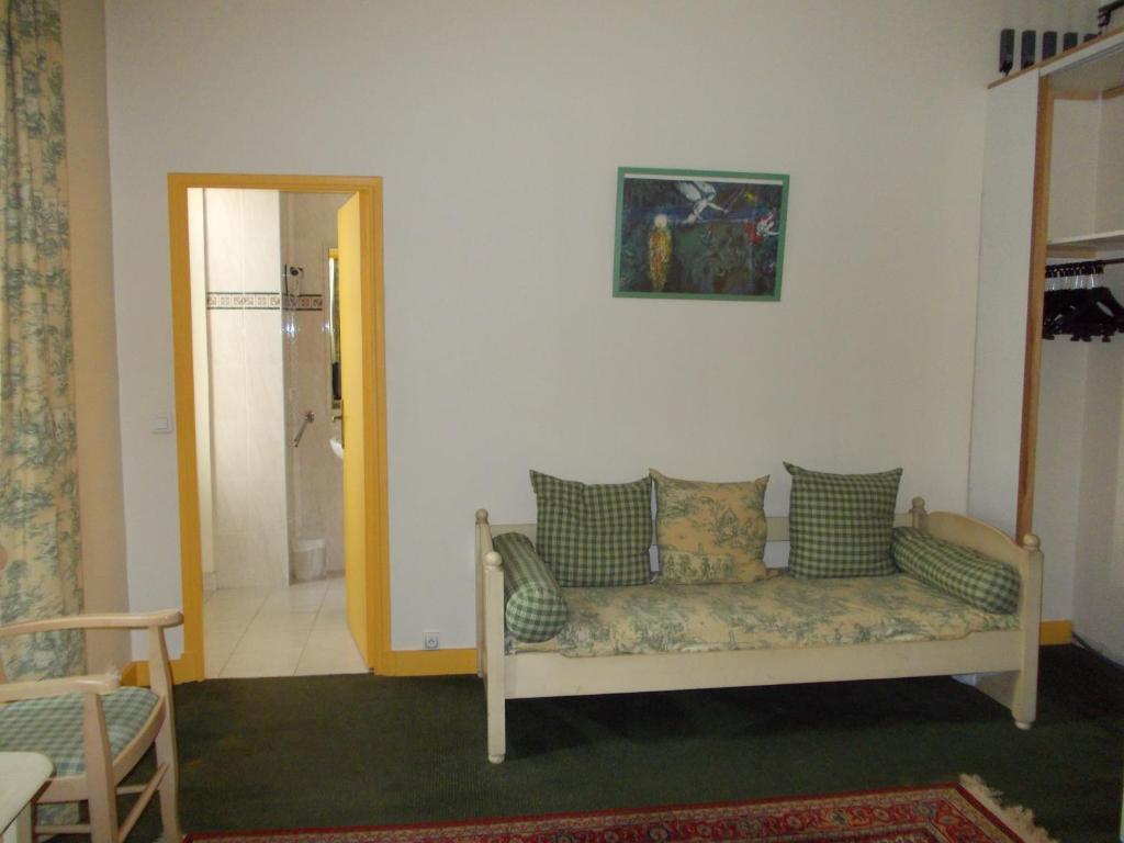 a living room with a couch and a mirror at Hotel Marcellin in Beaulieu-sur-Mer