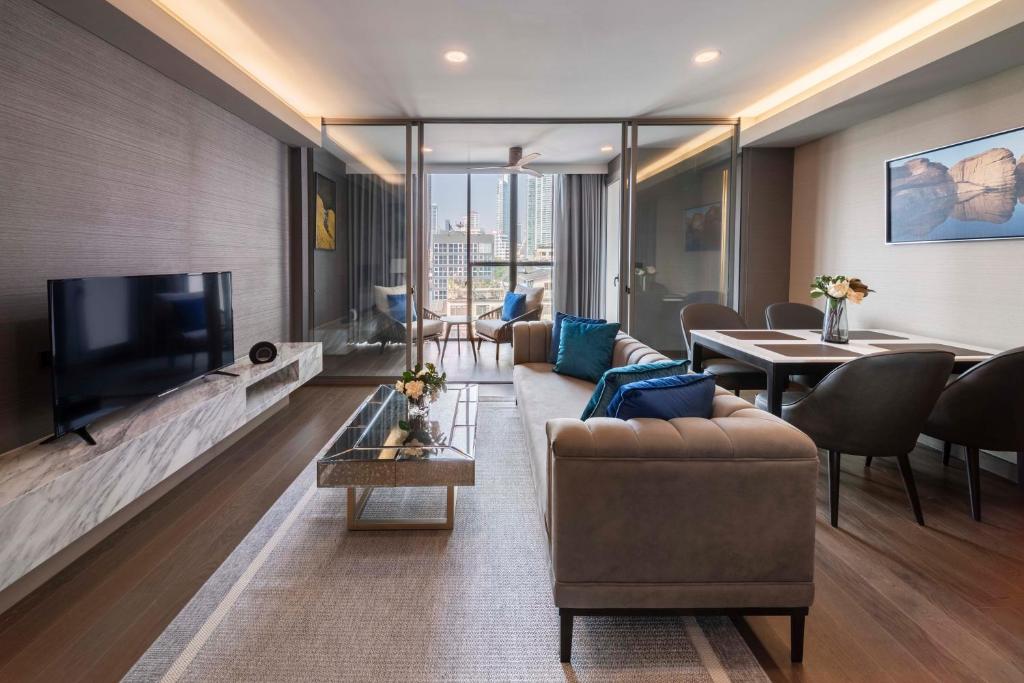 a living room with a couch and a tv at Wyndham Bangkok Queen Convention Centre in Bangkok