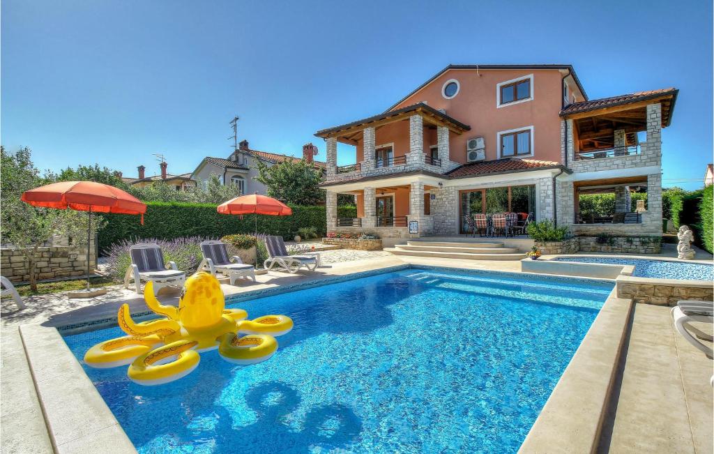 a swimming pool with a slide in front of a house at Beautiful Home In Buje With Kitchen in Buje