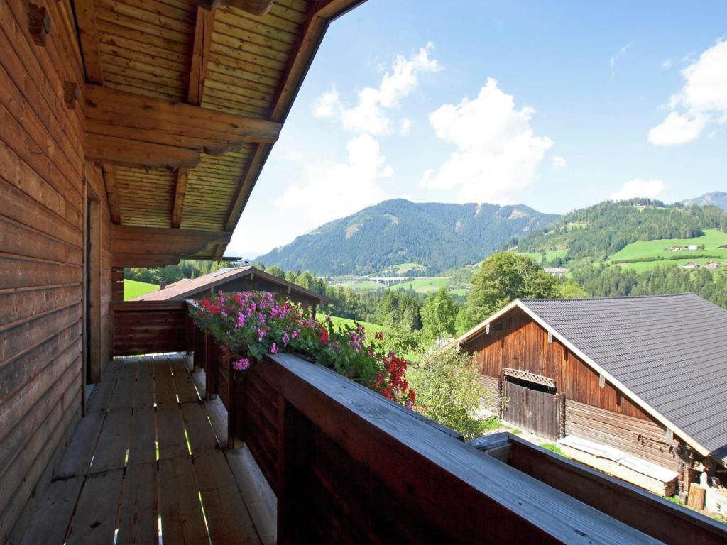 a balcony of a wooden house with flowers on it at Lush Holiday Home in H ttau near Ski Area in Hüttau