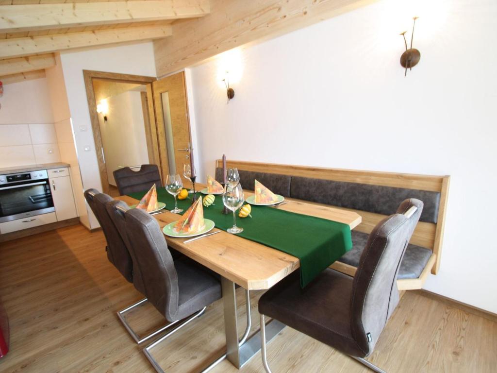 a dining room with a green table and chairs at Exquisite vacation apartment in Mittersill near ski area in Mittersill