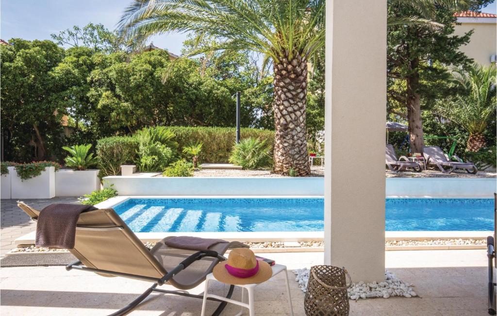 a patio with a chair and a swimming pool at 3 Bedroom Stunning Apartment In Makarska in Makarska