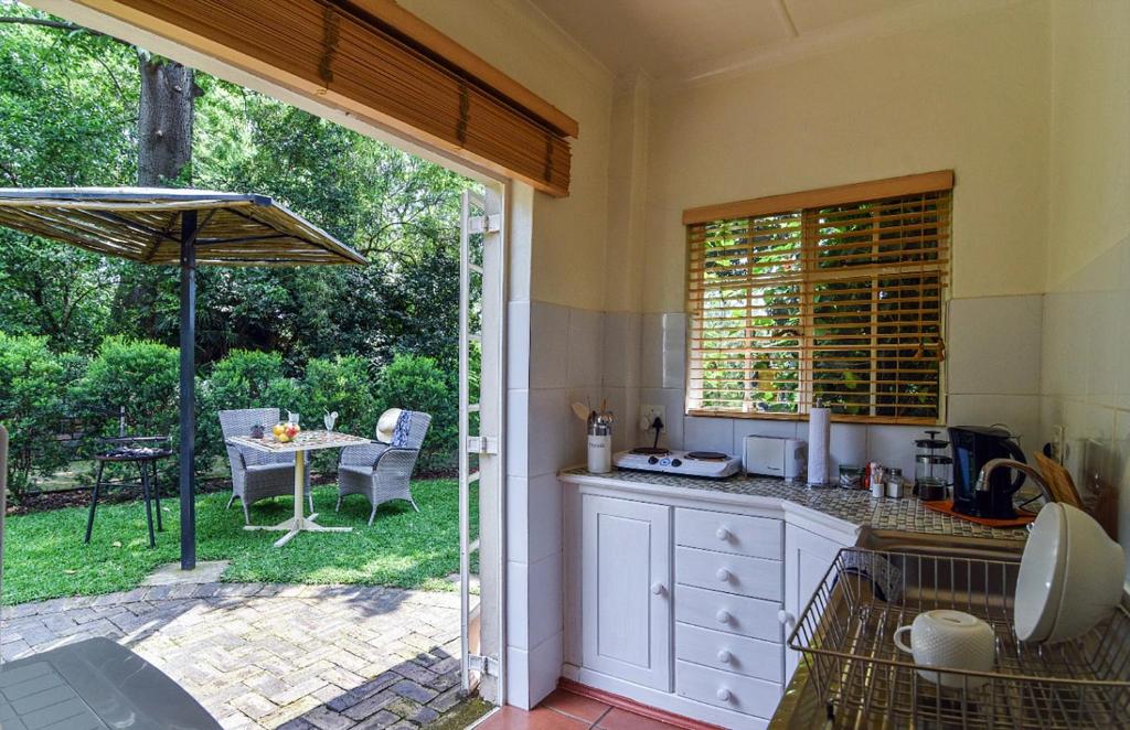 eine Küche mit einer offenen Tür zu einer Terrasse in der Unterkunft Random Harvest Country Cottages in Muldersdrift