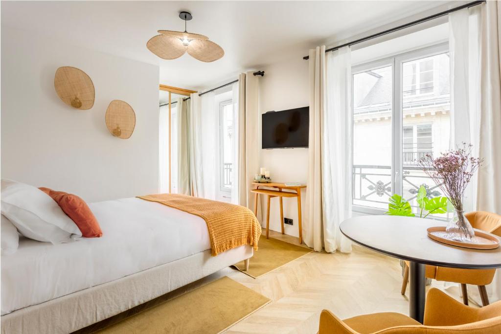 a bedroom with a bed and a table and a window at Best Stay Jeuneurs in Paris