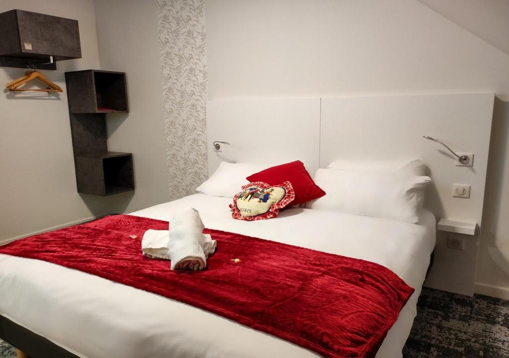een bed met een knuffeldier op een rode deken bij The Originals City, Hôtel Mulhouse Est in Rixheim